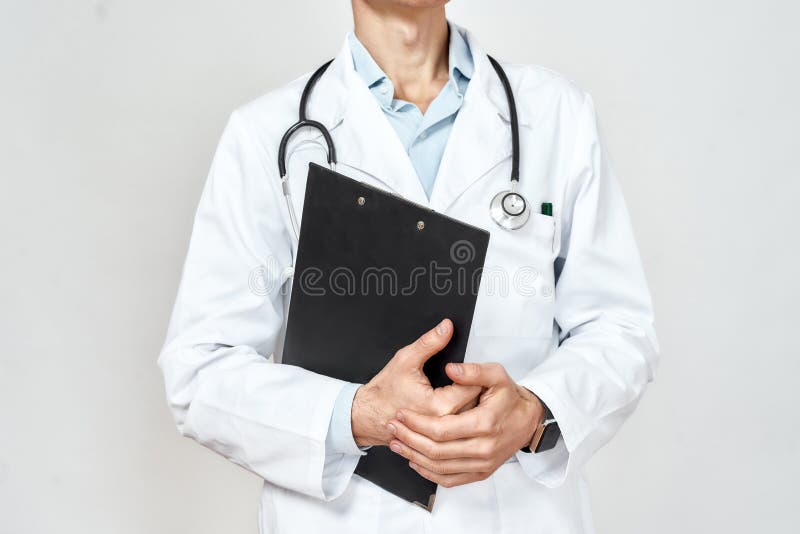 Médico no trabalho. foto cortada do médico profissional de uniforme médico com estetoscópio em volta do pescoço segurando papel pr fotos de stock royalty free