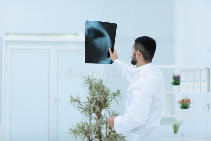 Médico que mira la imagen de la radiografía en hospital imágenes de archivo libres de regalías Médico que mira la imagen de la radiografía en hospital imágenes de archivo libres de regalías