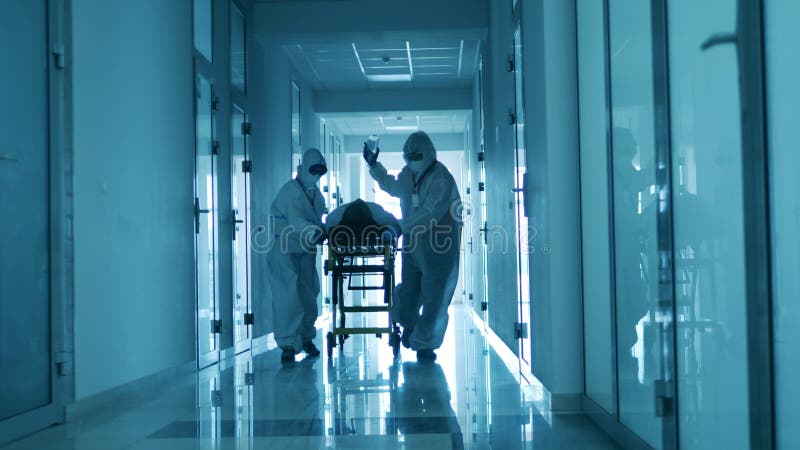 Médicos de emergencia transfieren a un hombre con coronavirus en camilla.