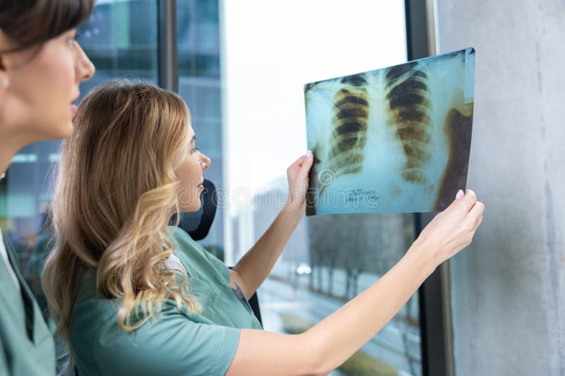 Médicos en la oficina de radiología discutiendo el diagnóstico de la salud mirando la imagen de rayos fotos de archivo libres de regalías