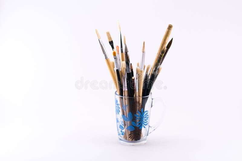 Mixture of different kinds and sizes of brushes and spatula in a cup on a white background. Mixture of different kinds and sizes of brushes and spatula in a cup on a white background.