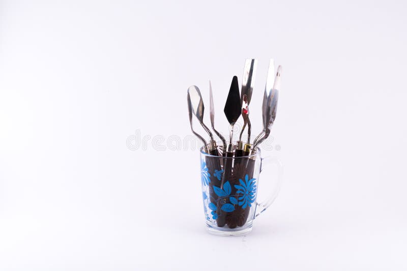 Mixture of different kinds and sizes of spatula in a transparent cup on a white background. Mixture of different kinds and sizes of spatula in a transparent cup on a white background.