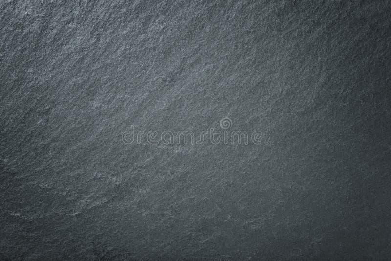 Light gray background of natural slate. Texture of black stone closeup. Light gray background of natural slate. Texture of black stone closeup