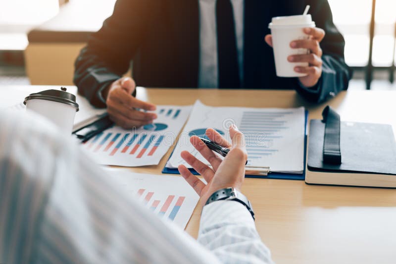 Two business people meeting and analysis finance summary report at table. Two business people meeting and analysis finance summary report at table