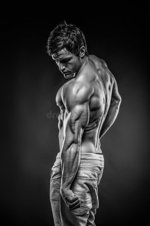 Músculos traseros de presentación modelo y tricep de la aptitud atlética fuerte del hombre imagen de archivo libre de regalías Músculos traseros de presentación modelo y tricep de la aptitud atlética fuerte del hombre imagen de archivo libre de regalías