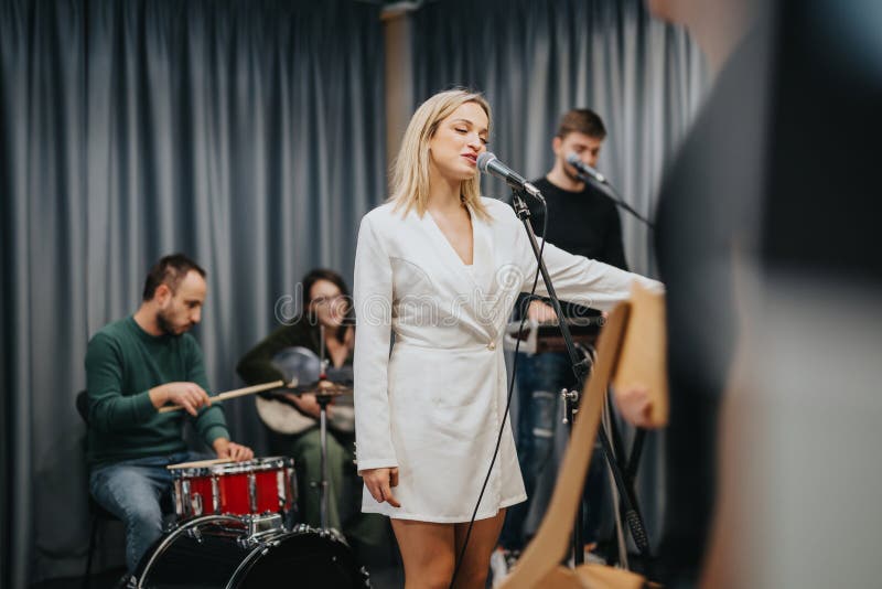 Música de banda con cantante femenina durante una animada sesión de ensayo imagenes de archivo