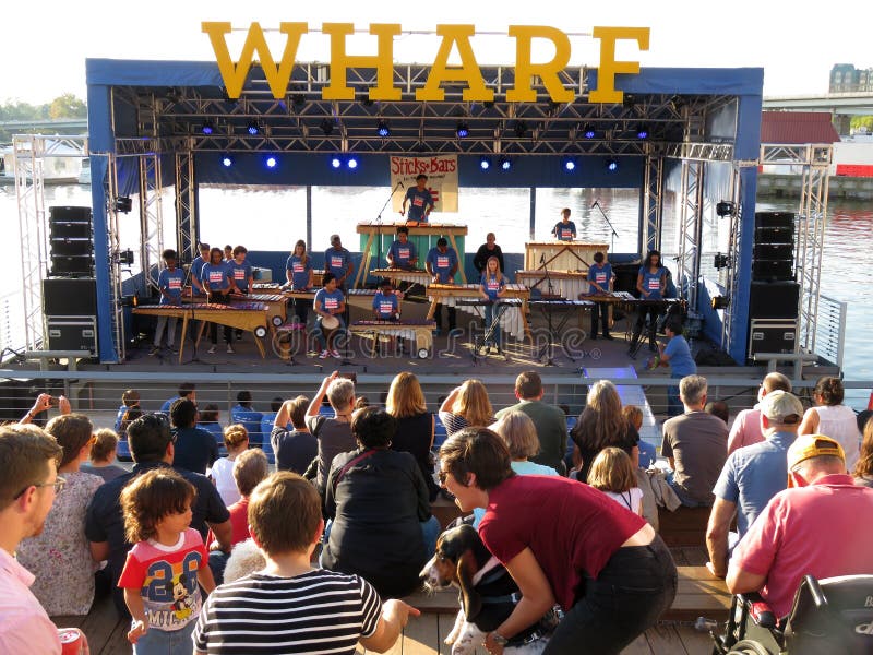 Photo of people enjoying free music at the wharf at the southwest waterfront in washington dc on 10/14/17 during the four day celebration of the grand opening featuring music entertainment and food offerings from restaurants as well as other activities. The old seafood restaurants were replaced with brand new buildings with restaurants, residential, offices, retail stores and dockage facilities. Photo of people enjoying free music at the wharf at the southwest waterfront in washington dc on 10/14/17 during the four day celebration of the grand opening featuring music entertainment and food offerings from restaurants as well as other activities. The old seafood restaurants were replaced with brand new buildings with restaurants, residential, offices, retail stores and dockage facilities.