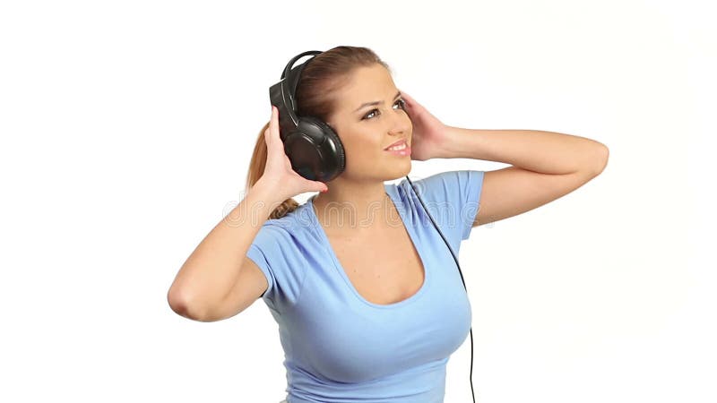 Música que escucha de la mujer hermosa joven en auriculares estéreos grandes