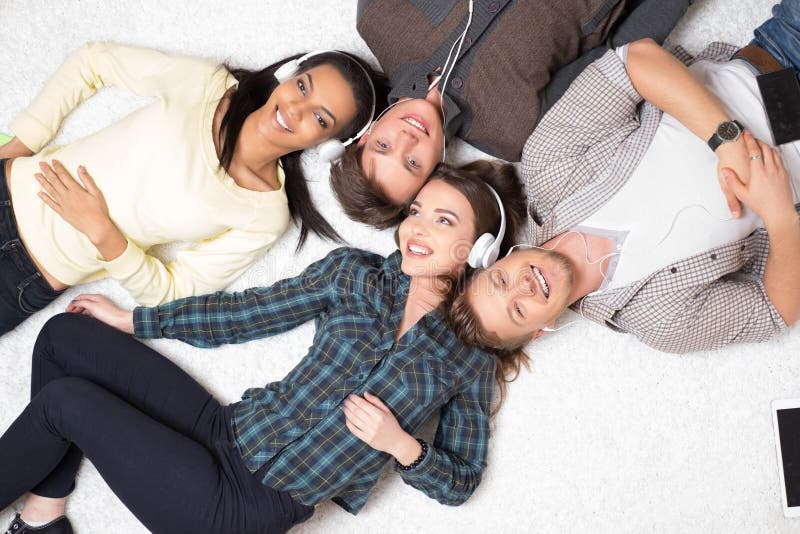 Música que escucha de los amigos multirraciales felices foto de archivo libre de regalías Música que escucha de los amigos multirraciales felices foto de archivo libre de regalías
