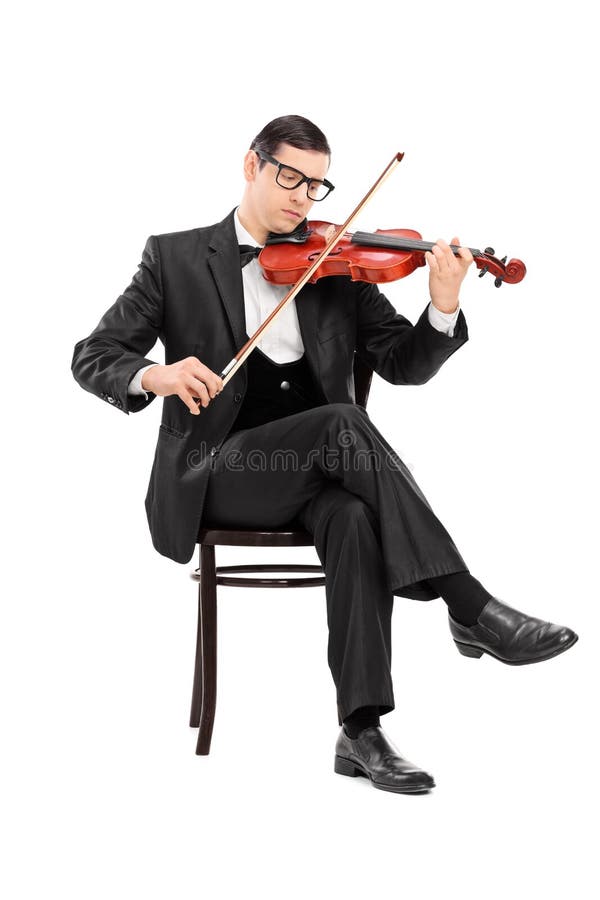Músico clássico que joga o violino assentado na cadeira foto de stock royalty free Músico clássico que joga o violino assentado na cadeira foto de stock royalty free