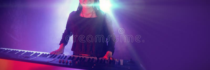 Músico fêmea que joga o piano no clube iluminado imagem de stock royalty free Músico fêmea que joga o piano no clube iluminado imagem de stock royalty free