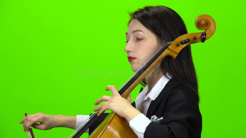 Músico toca violonchelo Pantalla verde Vista lateral Cerrar