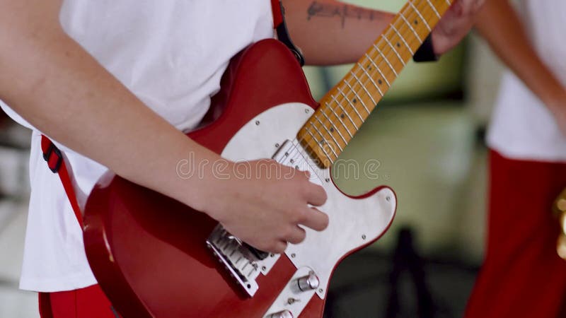 Músico tocando violão elétrico em um show no palco. performance ao vivo de um guitarrista com guitarra a cores de madeira