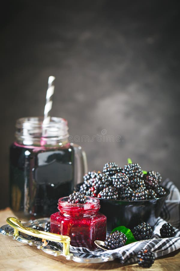 Ripe blackberry, blackberry juice and jam on a wooden table. Dark background. Dark background. Selective focus. Background with copy space. Ripe blackberry, blackberry juice and jam on a wooden table. Dark background. Dark background. Selective focus. Background with copy space.