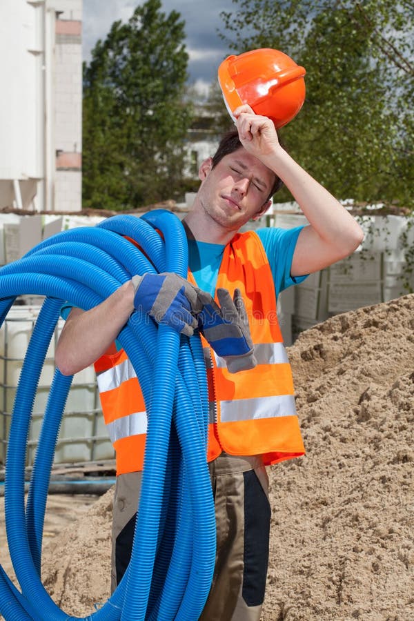 Müder Bauarbeiter, der Rohre hält stockfotos Müder Bauarbeiter, der Rohre hält stockfotos