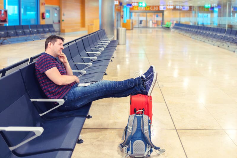 M?der mittlerer gealterter Mann, der mit den Beinen auf Koffer in der Abfahrthalle im Flughafen schl?ft stockfoto M?der mittlerer gealterter Mann, der mit den Beinen auf Koffer in der Abfahrthalle im Flughafen schl?ft stockfoto