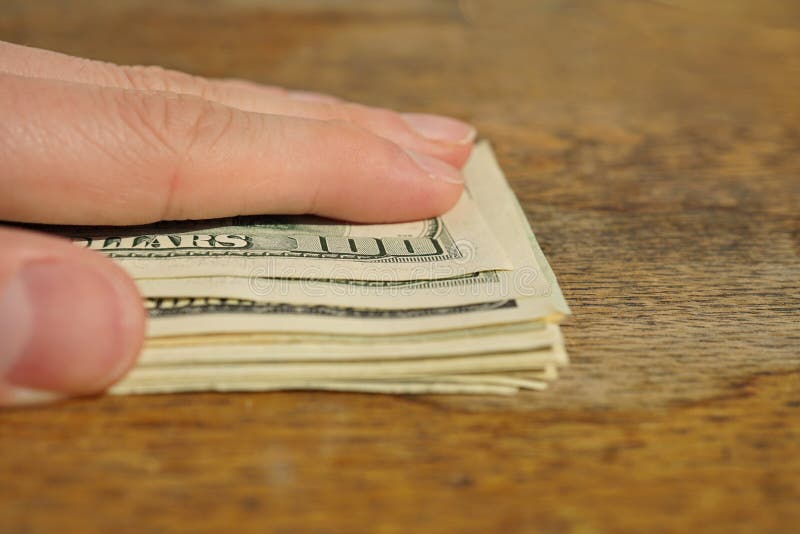 Męska ręka zakrywa rozsypisko Amerykańska pieniądze USA waluta, USD na drewnianym tle jako symbol bogactwo obrazy stock Męska ręka zakrywa rozsypisko Amerykańska pieniądze USA waluta, USD na drewnianym tle jako symbol bogactwo obrazy stock