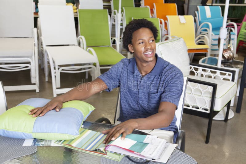 Male African American salesperson working in garden furniture store. Male African American salesperson working in garden furniture store