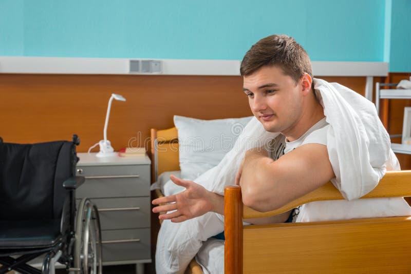Męski chory cierpliwy opierać na szpitalnym bedstead zakrywającym z q zdjęcie stock Męski chory cierpliwy opierać na szpitalnym bedstead zakrywającym z q zdjęcie stock