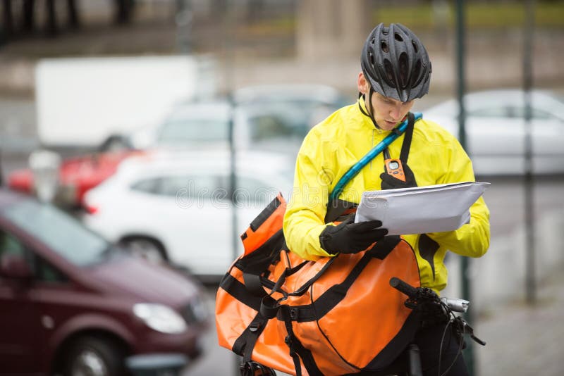 Męski cyklista Z pakunkiem Dalej I kurier torbą obraz stock Męski cyklista Z pakunkiem Dalej I kurier torbą obraz stock