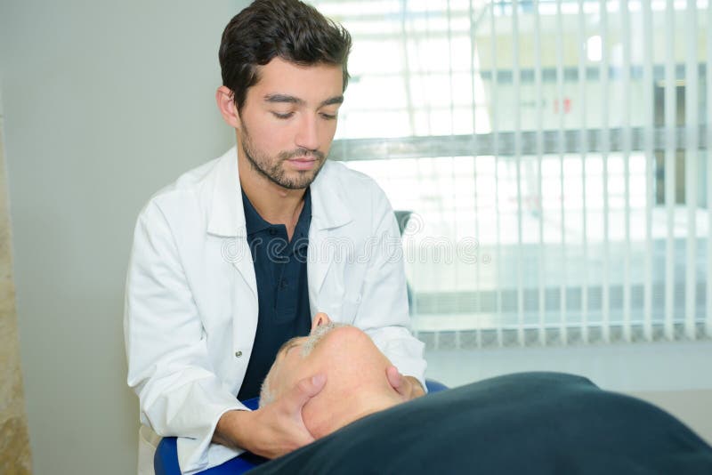 Męski physiotherapist daje kierowniczemu masażowi starszego pacjenta w klinice obrazy royalty free Męski physiotherapist daje kierowniczemu masażowi starszego pacjenta w klinice obrazy royalty free