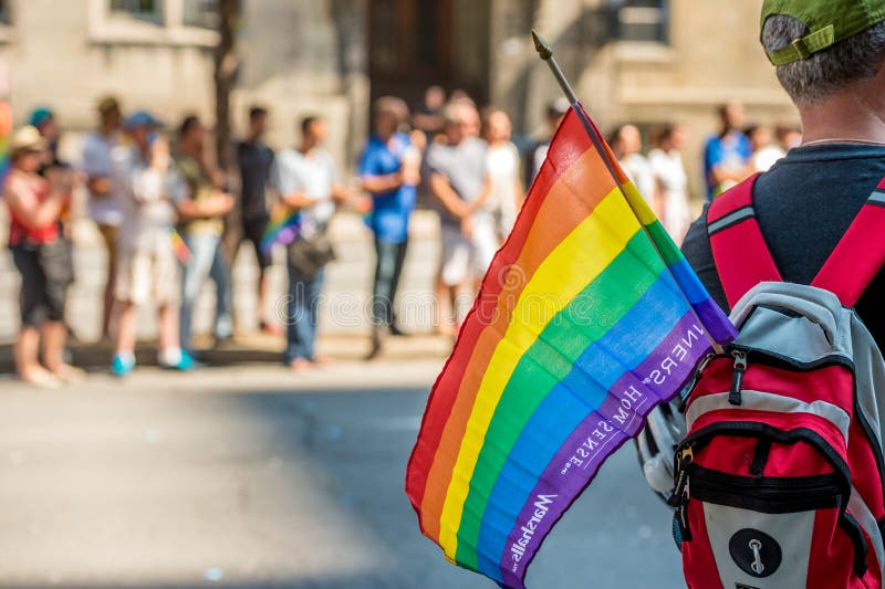 Męski widz niesie tęcza homoseksualisty flaga podczas Montreal dumy fotografia stock Męski widz niesie tęcza homoseksualisty flaga podczas Montreal dumy fotografia stock