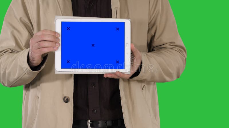 Męskie ręki trzyma pastylkę z błękitnego ekranu mockup na zielenieją ekran, chroma klucz