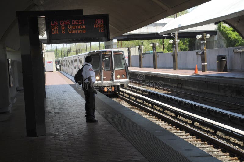 A man is waiting for a subway at the Cheverly staion one of the stations on the Washington DC;s subway system. A man is waiting for a subway at the Cheverly staion one of the stations on the Washington DC;s subway system