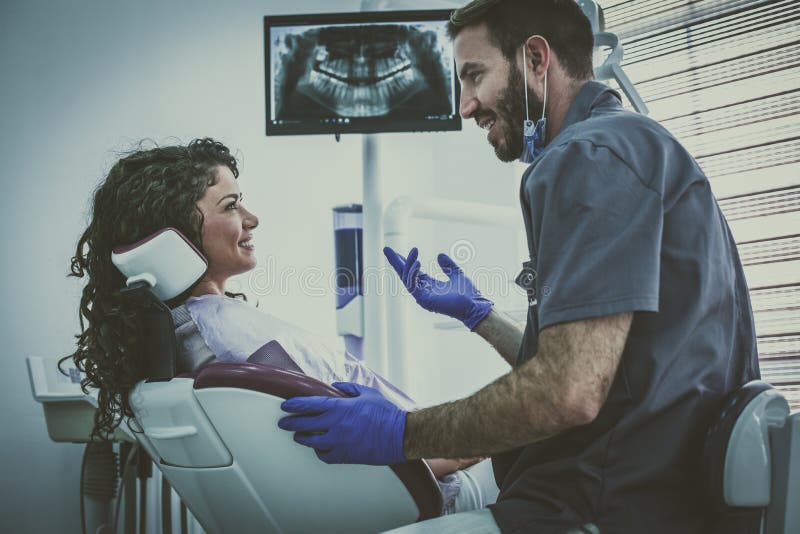 Mężczyzna dentysta ma dyskusja dowcipu pacjenta