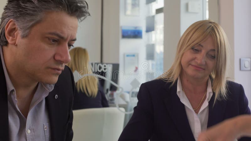 Mężczyzna i kobieta wybiera wakacyjną wycieczkę przy agencją podróży, kierownik podrzuca katalog zdjęcie wideo