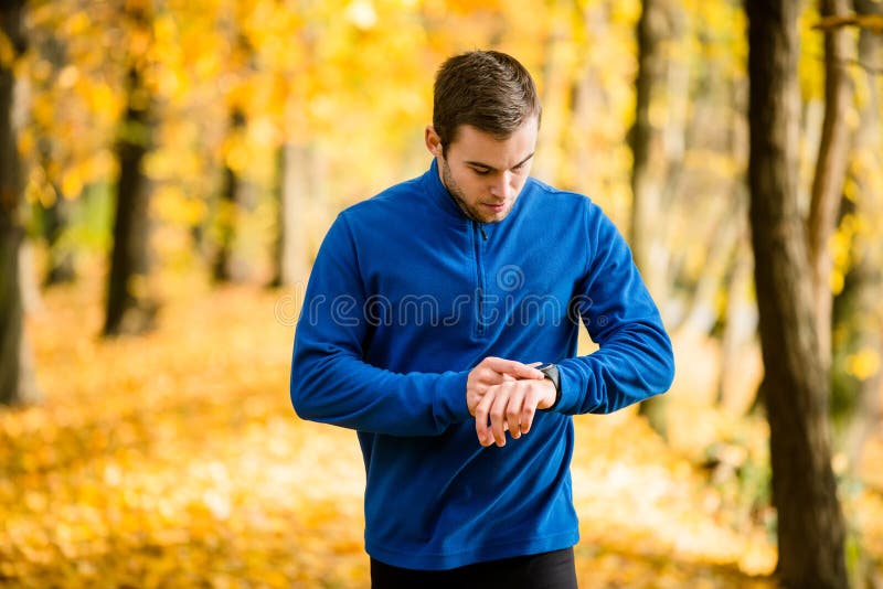 Mężczyzna jogging w naturze i sprawdza puls fotografia royalty free Mężczyzna jogging w naturze i sprawdza puls fotografia royalty free