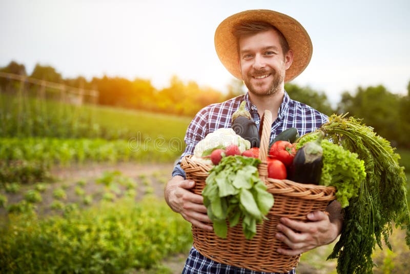 Mężczyzna mienia kosz z organicznie warzywami
