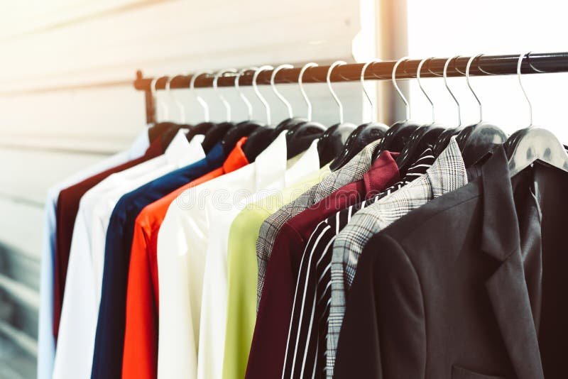 Men fashion clothes / Hanging clothes suit colorful or closet rack different coloured man suits in a closet on hangers in a store or showroom. Men fashion clothes / Hanging clothes suit colorful or closet rack different coloured man suits in a closet on hangers in a store or showroom