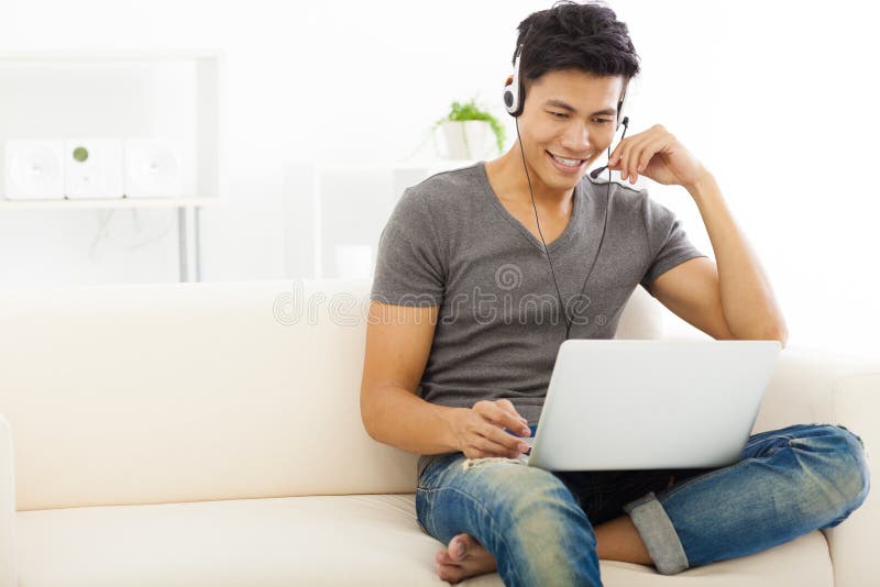 Young Man sitting in sofa and using laptop. Young Man sitting in sofa and using laptop