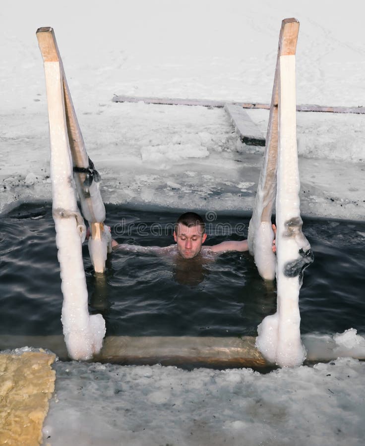 A man diving in the ice-hole on the Lake in winter day. A man diving in the ice-hole on the Lake in winter day