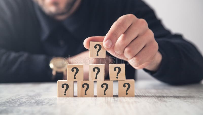 Man showing question mark on wooden cube. Man showing question mark on wooden cube