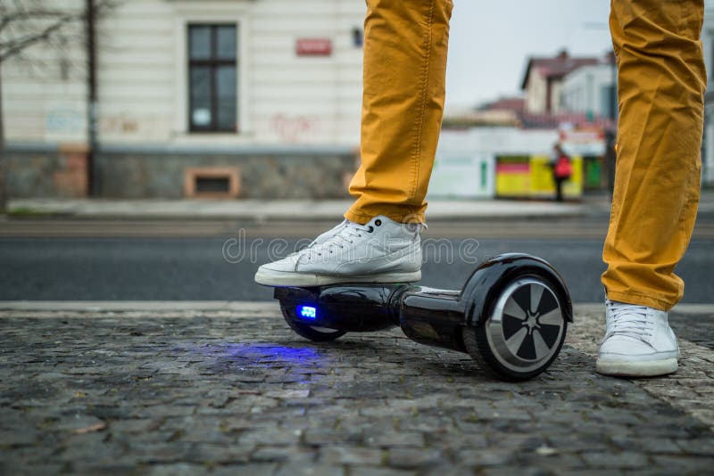 Man standing with black hoverboard on the street. Man standing with black hoverboard on the street