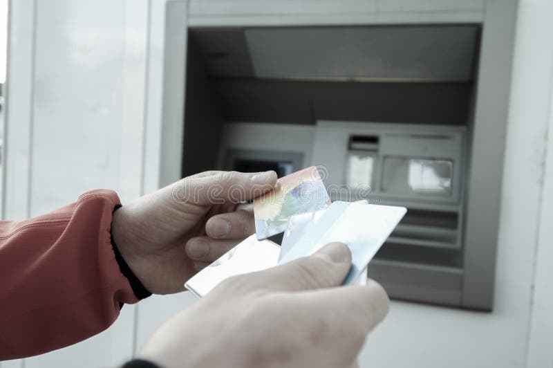 Mężczyzna przy ATM maszyną z chuje kredyt i karty debetowe obrazy royalty free Mężczyzna przy ATM maszyną z chuje kredyt i karty debetowe obrazy royalty free