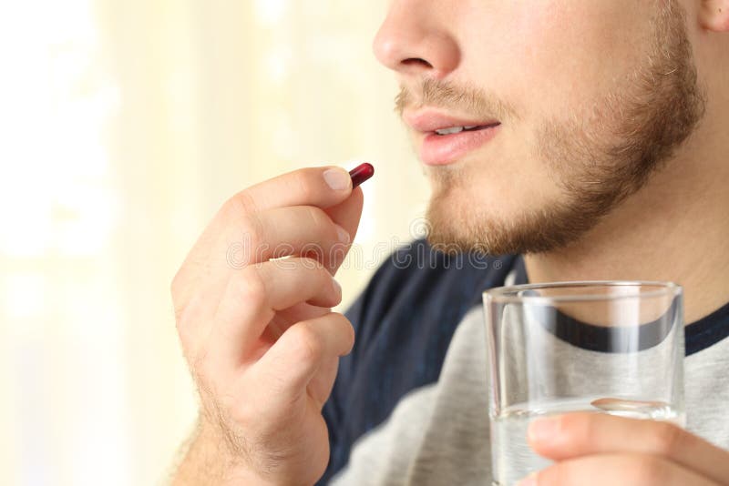 Close up of a man ready to swallow a pill. Close up of a man ready to swallow a pill