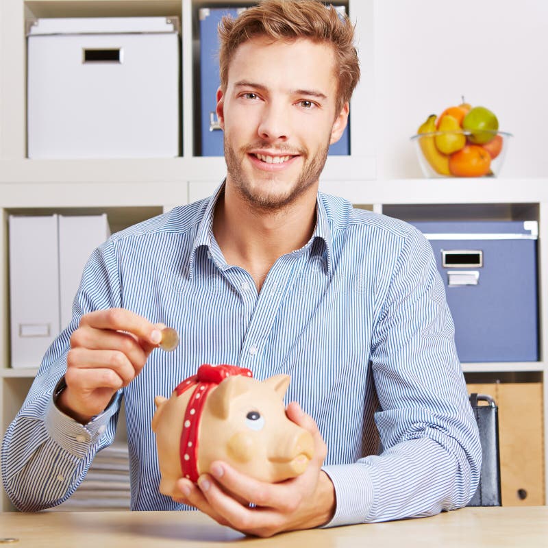 Mężczyzna ratuje Euro pieniądze w prosiątko banku zdjęcia stock Mężczyzna ratuje Euro pieniądze w prosiątko banku zdjęcia stock