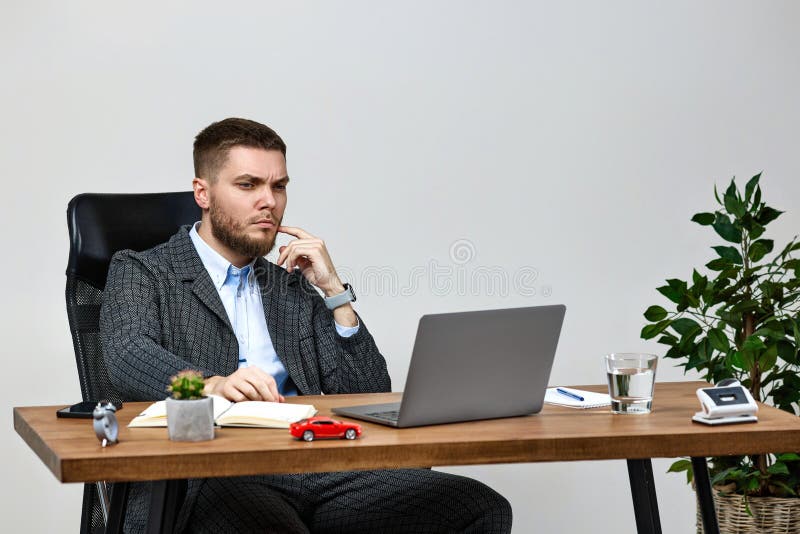 Mężczyzna siedzący na krześle przy stole i spoczywający na laptopie zdjęcia stock
