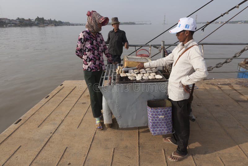 Mężczyzna sprzedaje smażących banany przy ferryboat w Kambodża zdjęcie stock Mężczyzna sprzedaje smażących banany przy ferryboat w Kambodża zdjęcie stock