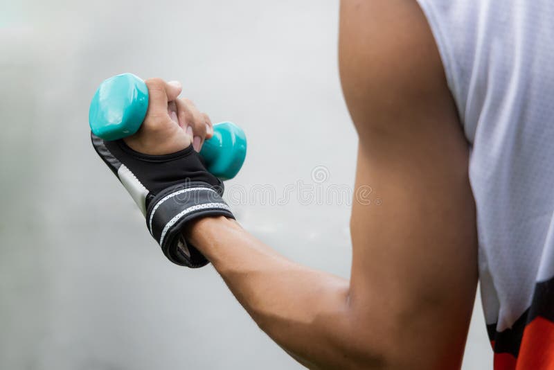 Mężczyzna trzyma dzwonek podczas treningu bokserskiego. jest silniejszy
