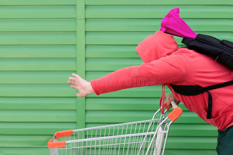 Mężczyzna w czerwonej kurtce z kapiszonem na jego głowie i plecakiem na jego z powrotem z barwionym pakunkiem szybko stacza się f zdjęcia stock Mężczyzna w czerwonej kurtce z kapiszonem na jego głowie i plecakiem na jego z powrotem z barwionym pakunkiem szybko stacza się f zdjęcia stock