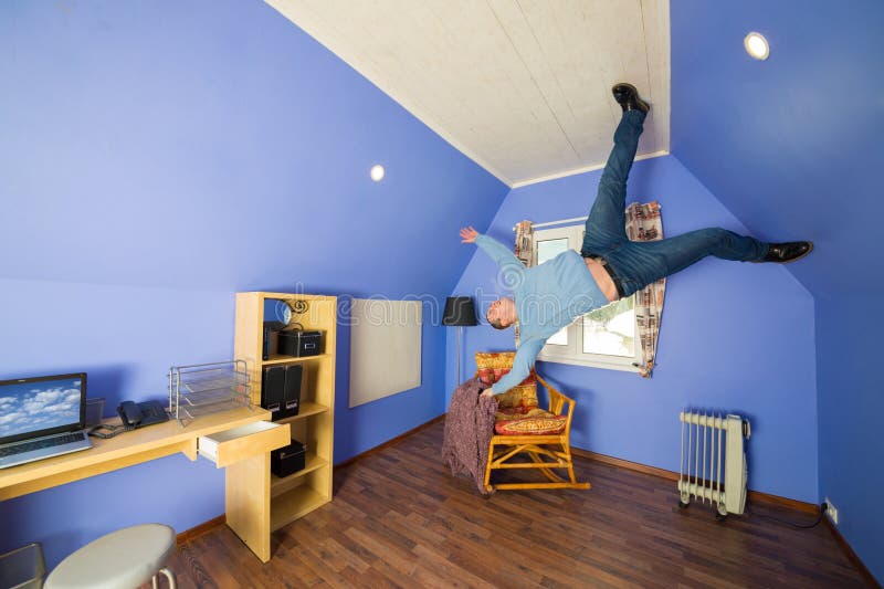 Man in jeans running on the ceiling upside down at inverted house. Man in jeans running on the ceiling upside down at inverted house