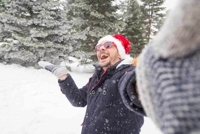 Mężczyzna w Santa kapeluszu bierze selfie na śnieżnym dniu okularach przeciwsłonecznych i zdjęcia stock Mężczyzna w Santa kapeluszu bierze selfie na śnieżnym dniu okularach przeciwsłonecznych i zdjęcia stock