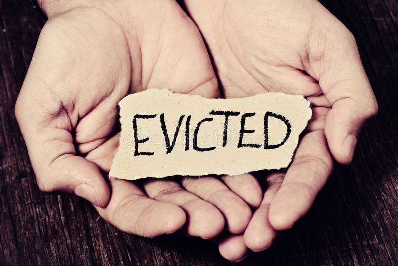 Closeup of a piece of paper with the word evicted in the hands of a caucasian man. Closeup of a piece of paper with the word evicted in the hands of a caucasian man