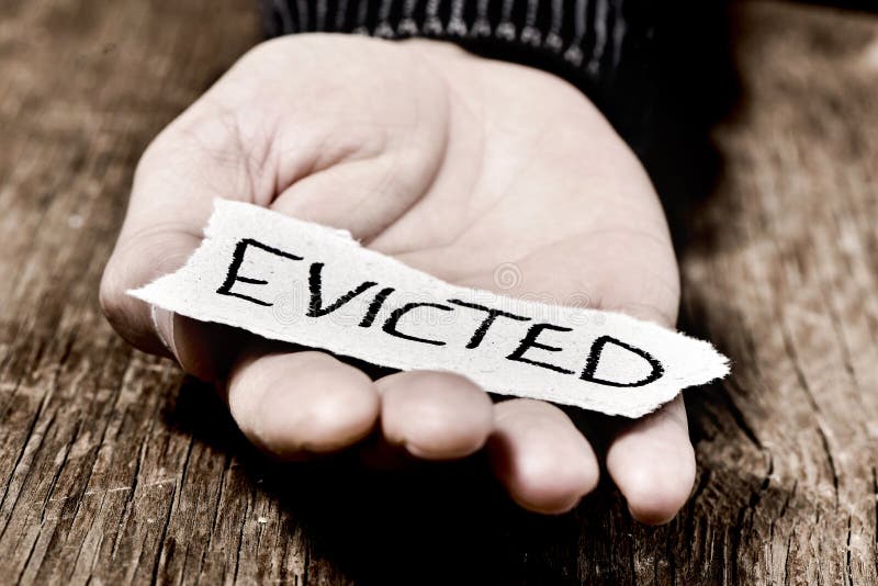 Closeup of a piece of paper with the word evicted in the hand of a caucasian man. Closeup of a piece of paper with the word evicted in the hand of a caucasian man