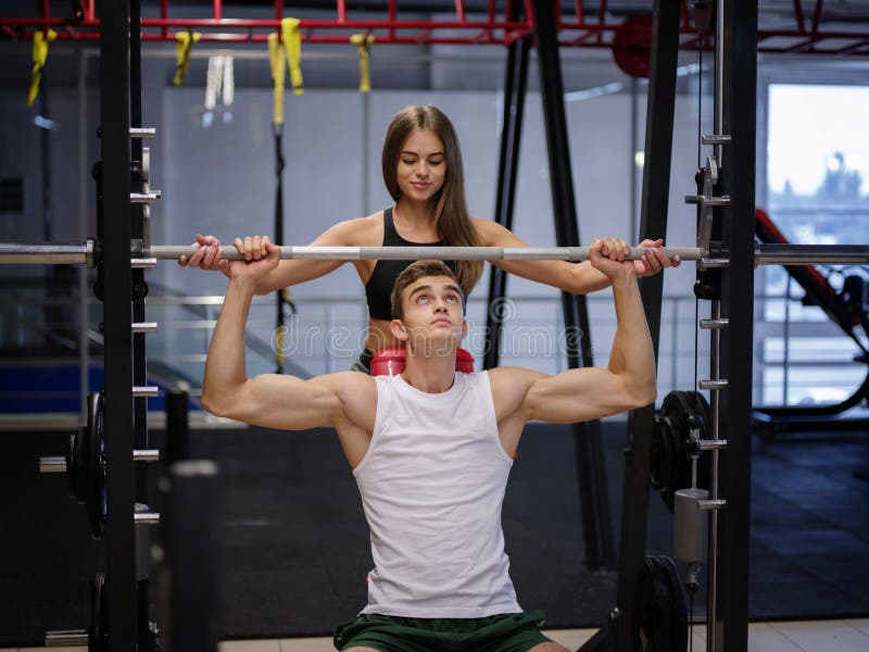 Mężczyzna z pięknym sportowym ciałem robi ćwiczeniom z barbell na gym tle sprawność fizyczna, bodybuilding pojęcie zdjęcie royalty free