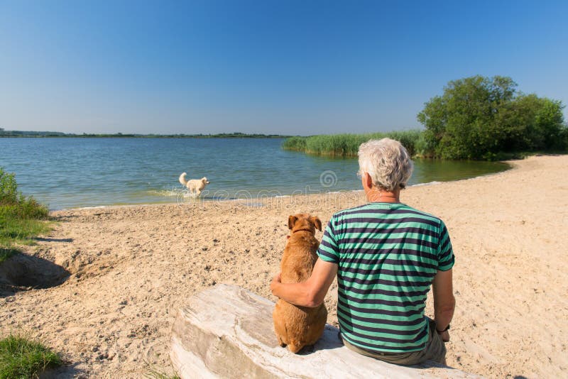 Mężczyzna z psem w krajobrazie z rzeką obraz stock